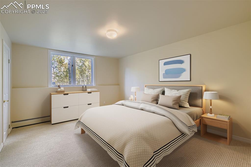 Bedroom with a baseboard radiator and light colored carpet