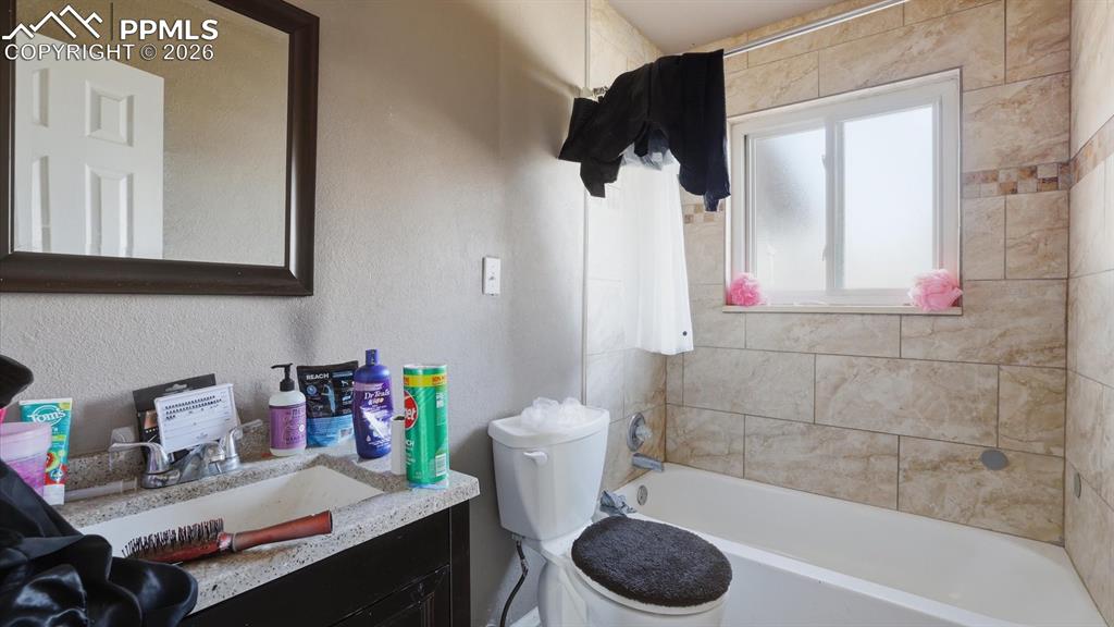 Upper Level Full Bathroom with vanity, framed mirror, and tiled tub/shower.