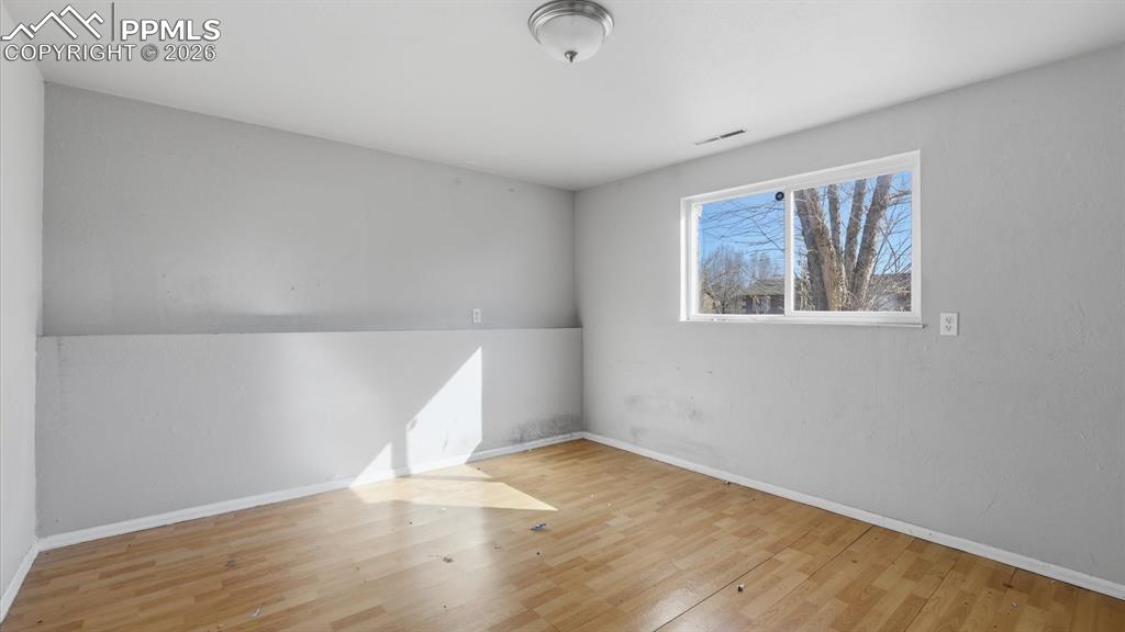 Lower Level Bedroom #3 with wood laminate flooring and window.