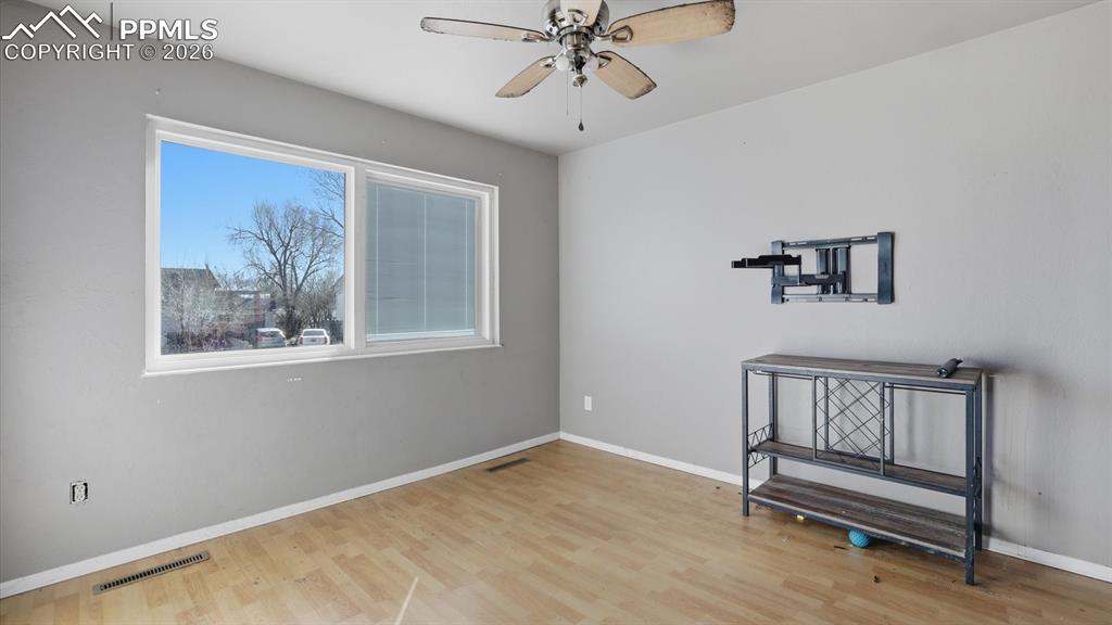 The Living Room features wood laminate flooring, a lighted ceiling fan, and view window to the front yard.
