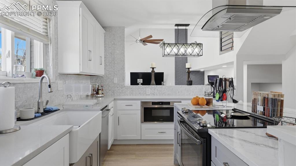 The Kitchen features white cabinetry, quartz countertops and a farm style sink.