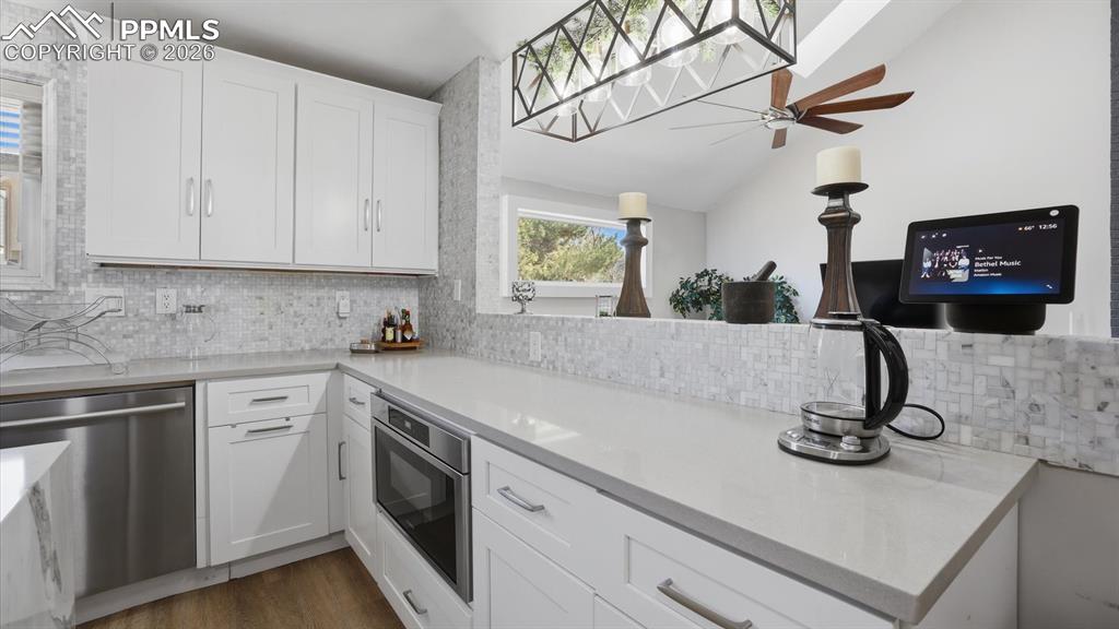 Attractive modern light fixture over the Kitchen and view into the Lower Level Family Room.
