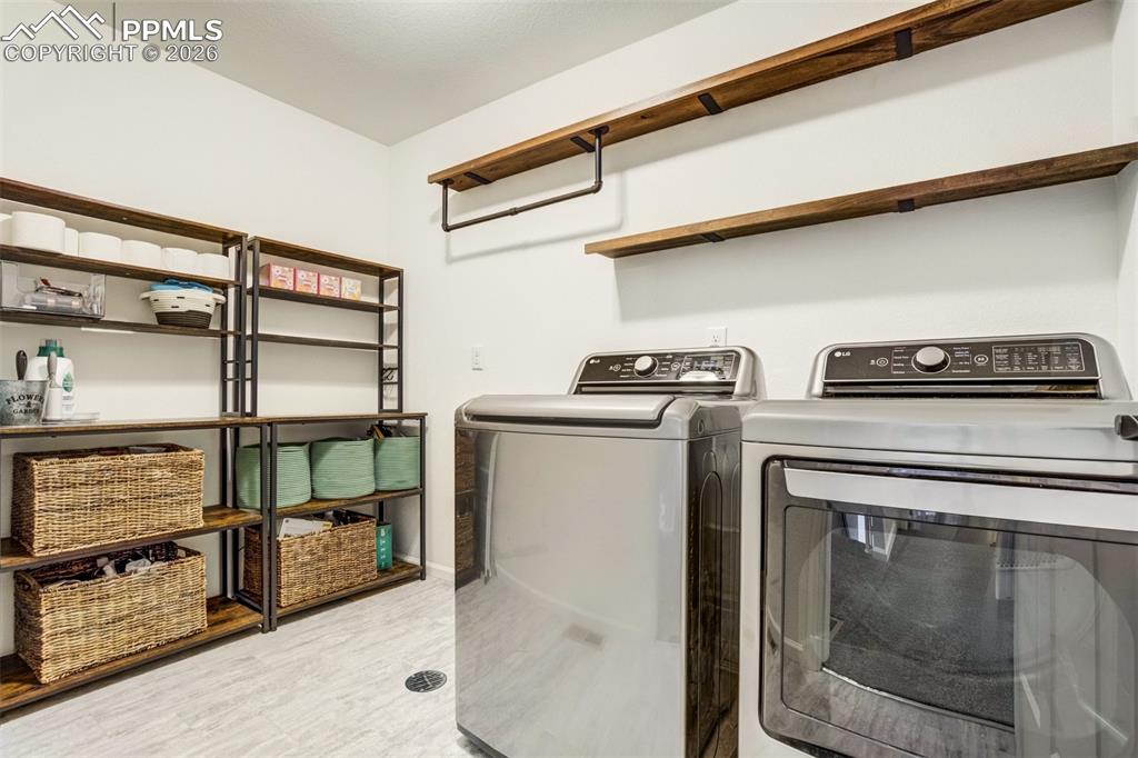 Even the laundry room is design worthy. Overhead shelving & plenty of storage. `