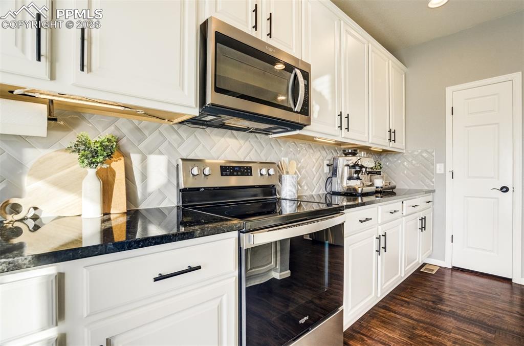Granite counters with herringbone design tile backsplash. 