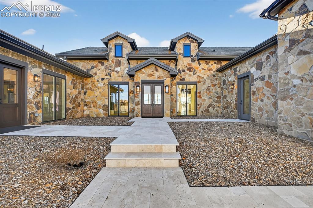 Property entrance with stone siding and french doors