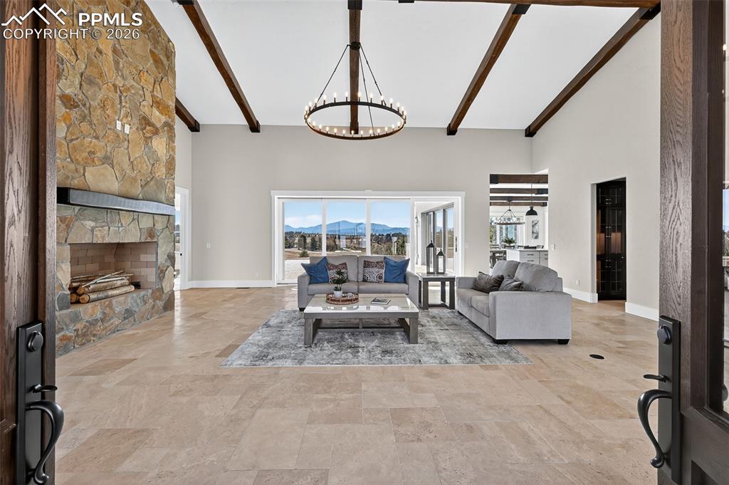 Living area with a chandelier, vaulted ceiling, a mountain view, and a fireplace
