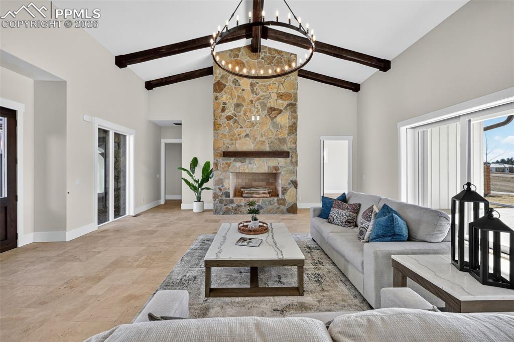 Living room with stone finish floors, a fireplace, and suspended lighting