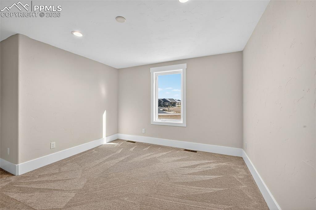 Spare room featuring baseboards and light carpet