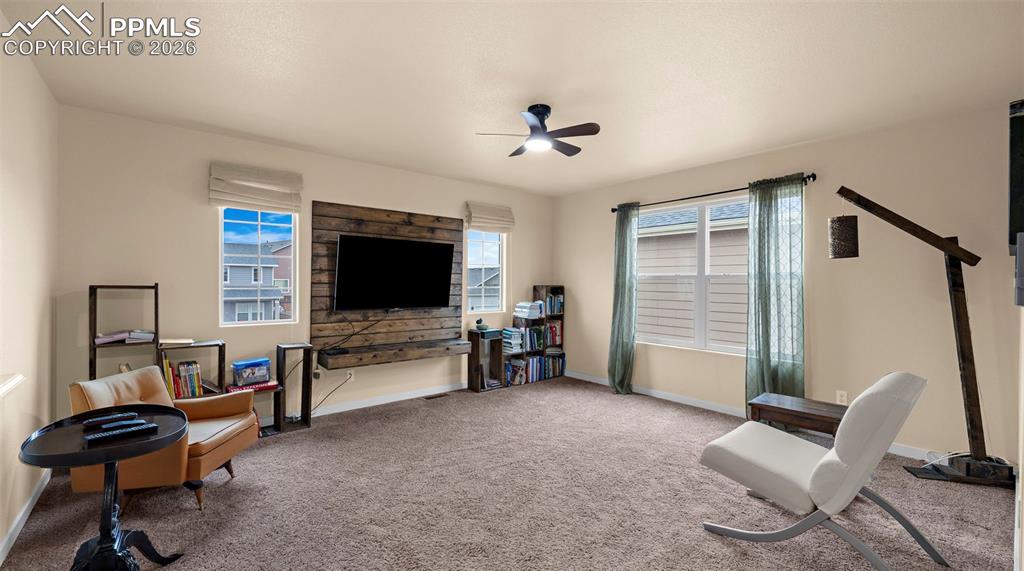Sitting room featuring a ceiling fan and carpet floors