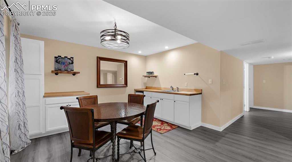 Dining space with dark wood-style flooring and recessed lighting