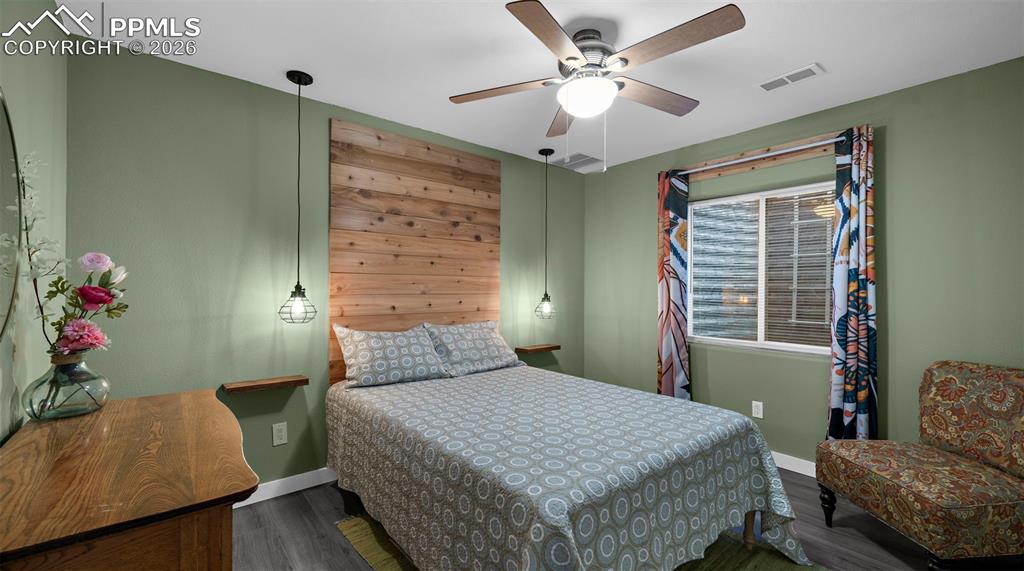 Bedroom with dark wood-type flooring and ceiling fan