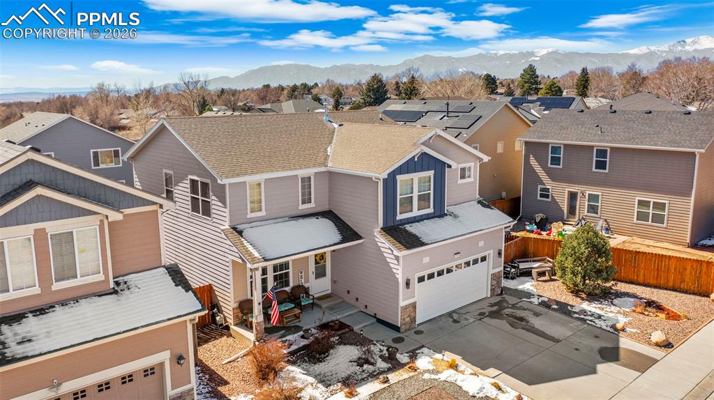 View of front of home featuring a garage, a residential view, driveway, and a mountain view