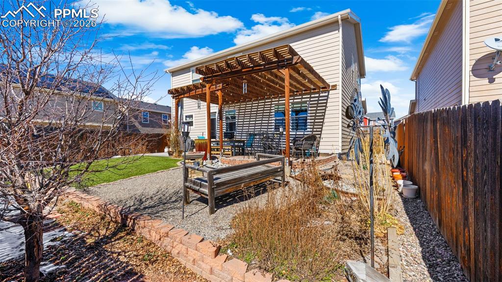 Rear view of house featuring a pergola, a patio area, and a fenced backyard