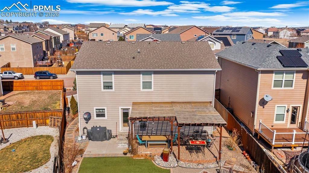 Back of house with a patio, a fenced backyard, a residential view, and roof with shingles