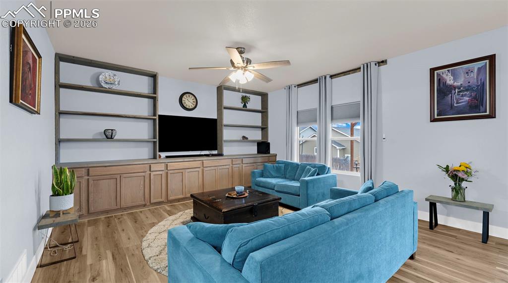 Living room featuring ceiling fan and light wood-style flooring