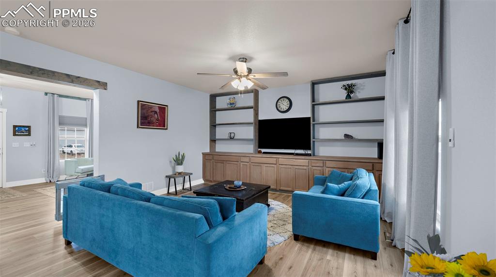Living room with light wood-style flooring and ceiling fan