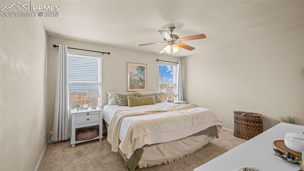 Bedroom featuring light colored carpet and a ceiling fan