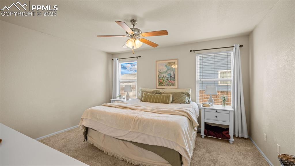 Bedroom with light colored carpet and ceiling fan