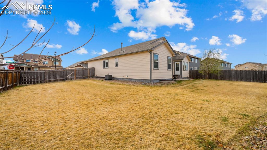 Rear view of house with a fenced backyard and a residential view