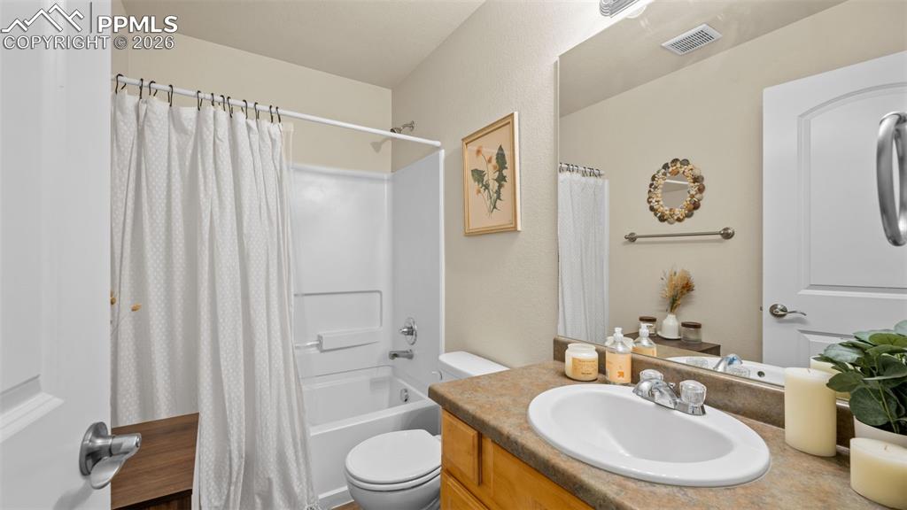 Bathroom featuring vanity and shower / tub combo with curtain
