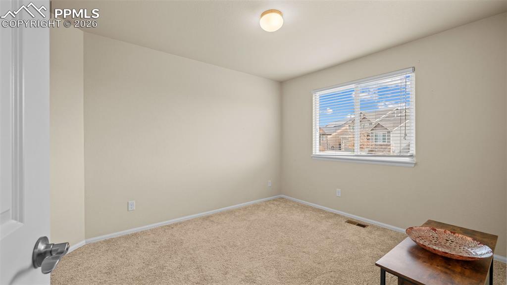 Spare room featuring light colored carpet and baseboards