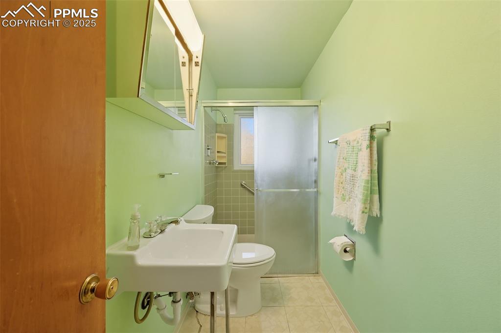 Lower bathroom featuring a stall shower and tile patterned floors