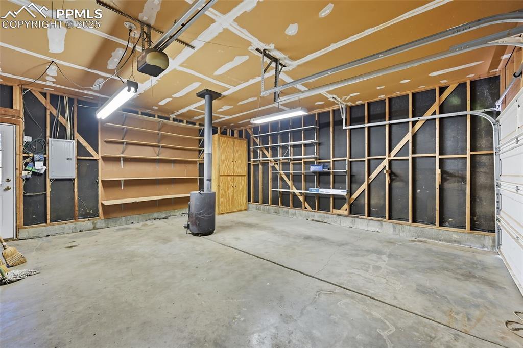 Garage with heat source and built in shelving and a workspace out of view