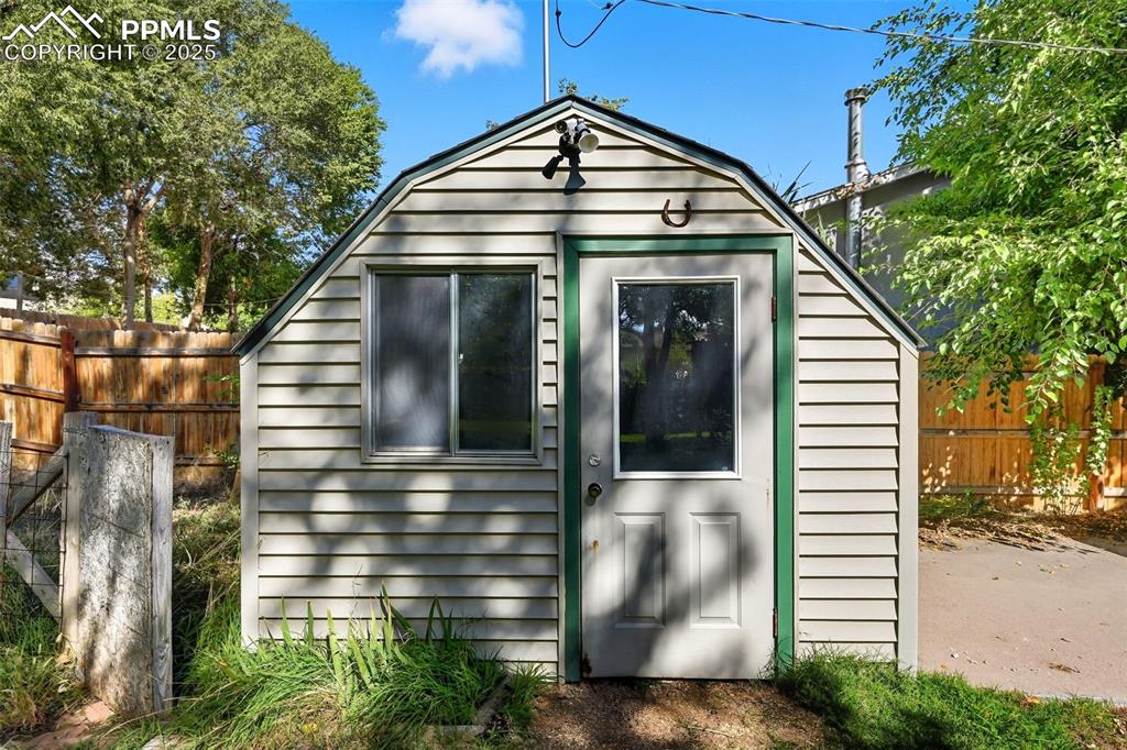 View of outdoor shed featuring a flood light and electric outlets