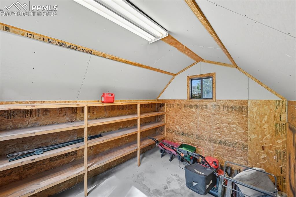 View of inside shed featuring electric outlets and lighting