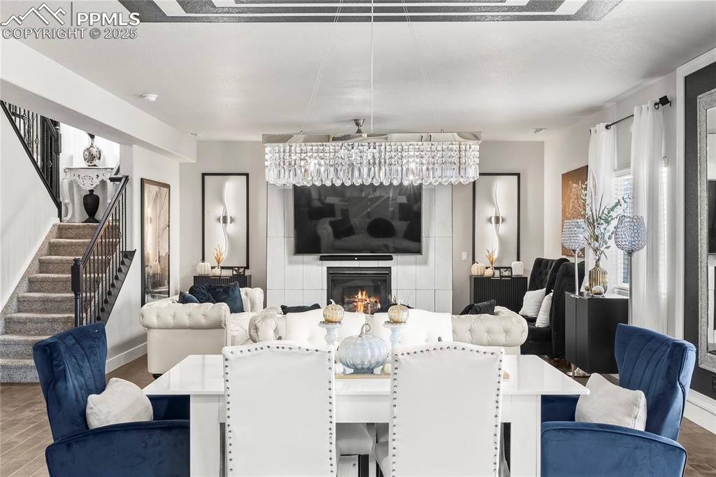 Dining area featuring a glass covered fireplace, stairway, and wood finished floors