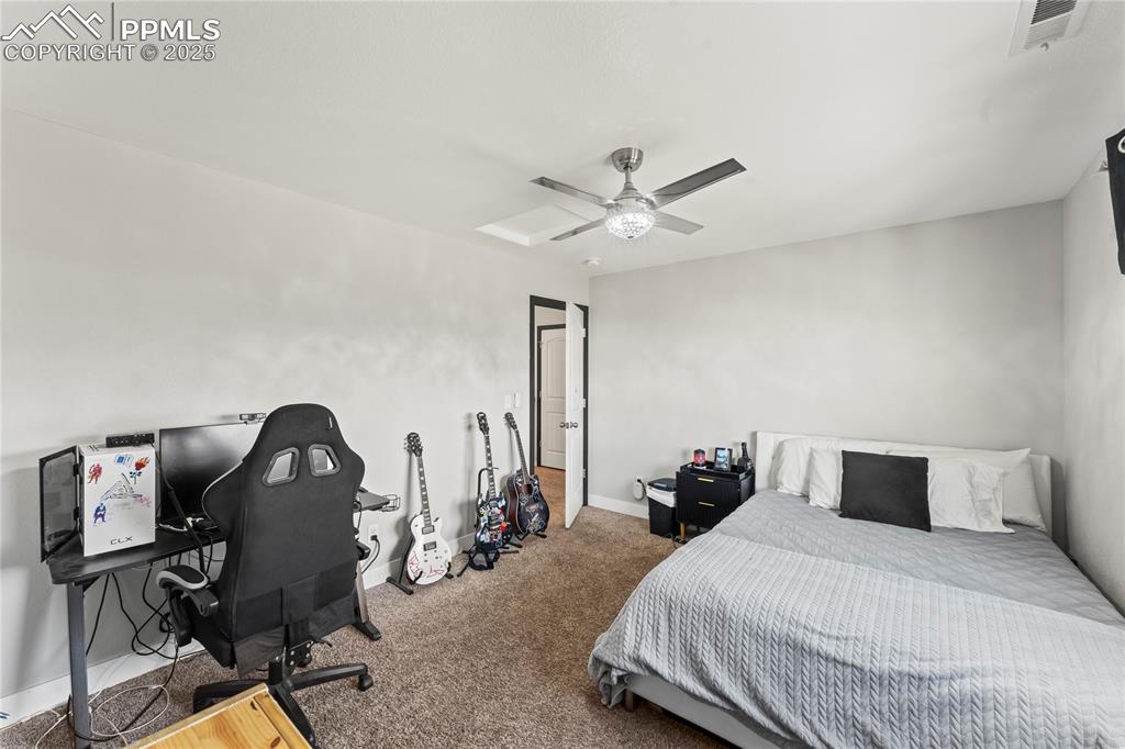 Bedroom with ceiling fan, carpet floors, and an office area