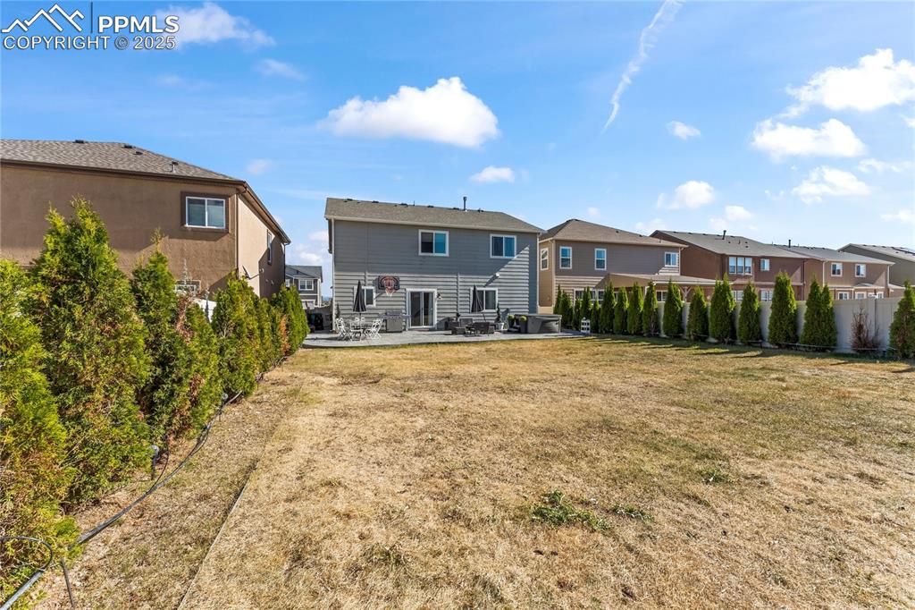 Rear view of property featuring a fenced backyard, a patio, and a residential view