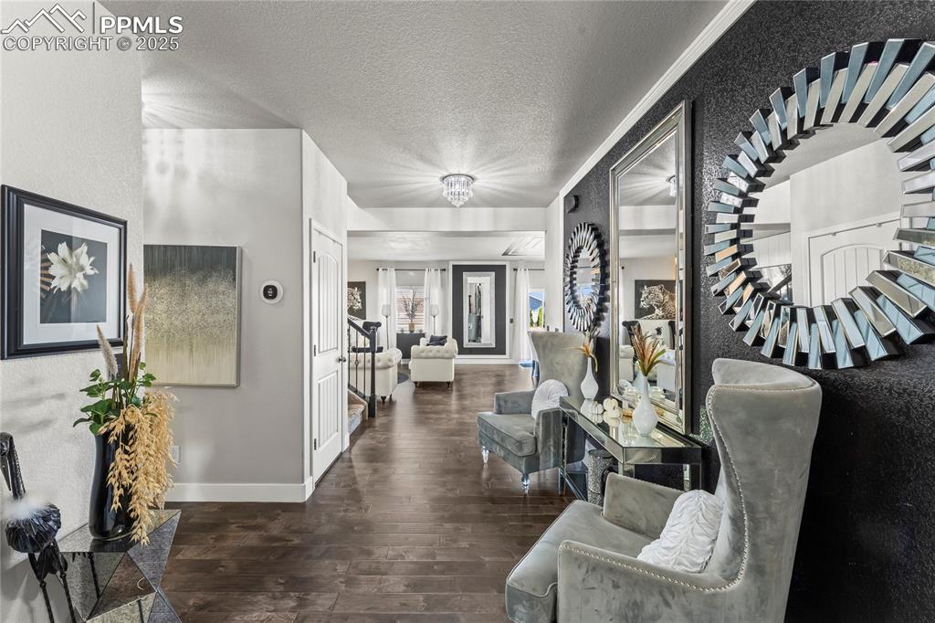 Hall with dark wood-style floors, a textured ceiling, and stairs