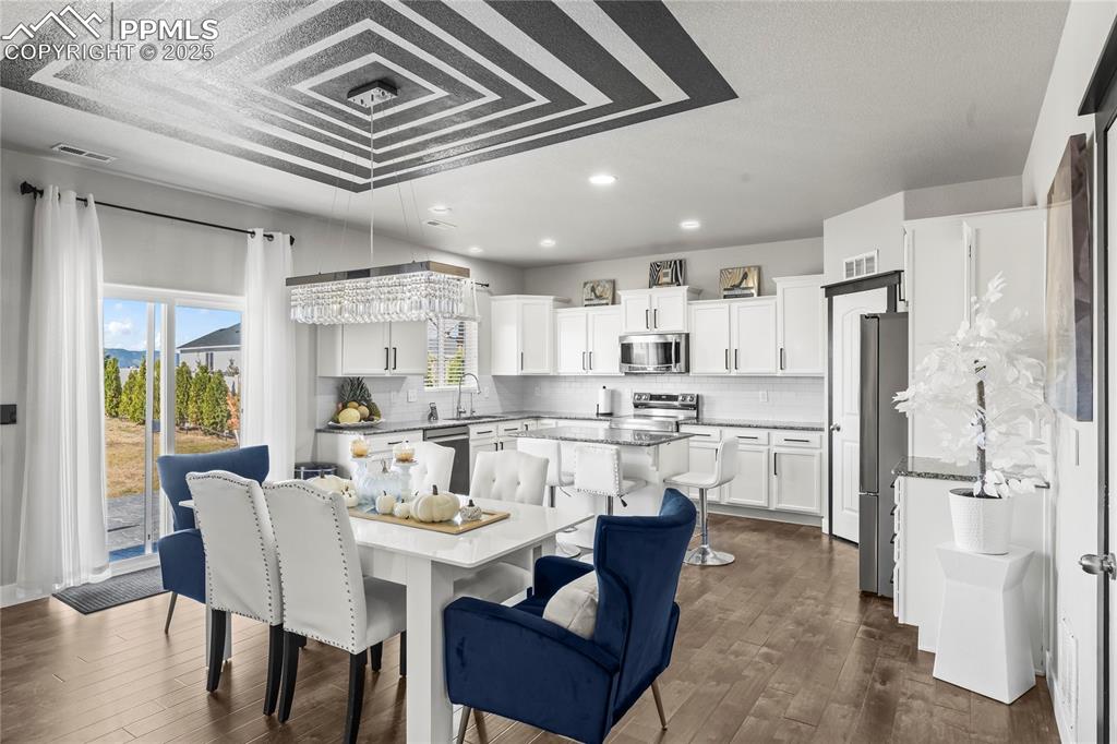 Dining area with recessed lighting and dark wood finished floors