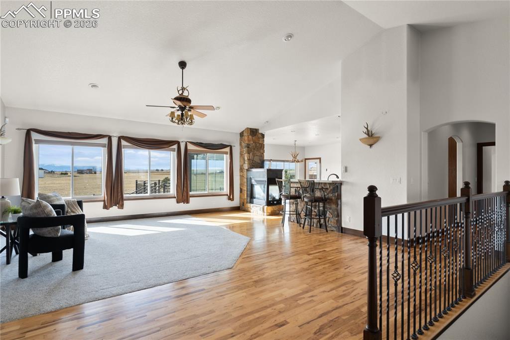 Open living room and kitchen with three-sided fireplace and mountain views of the Front Range