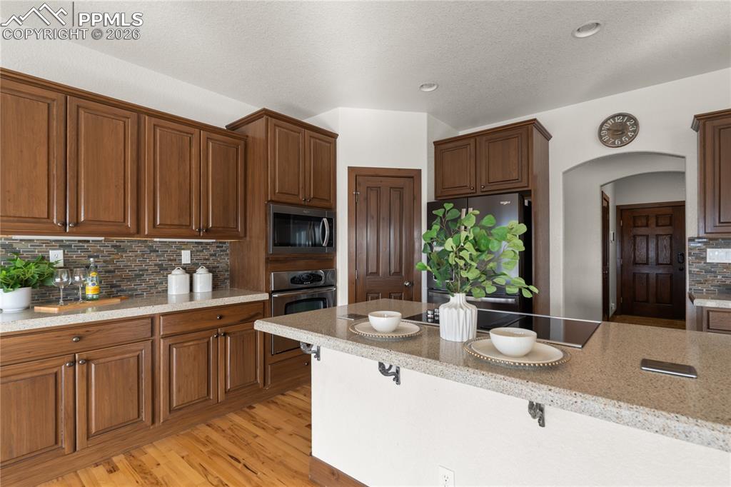 Kitchen with stainless steel appliances, solid surface countertops, and instant hot water