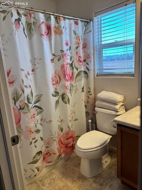 Bathroom with vanity, a shower with shower curtain, and light tile patterned floors