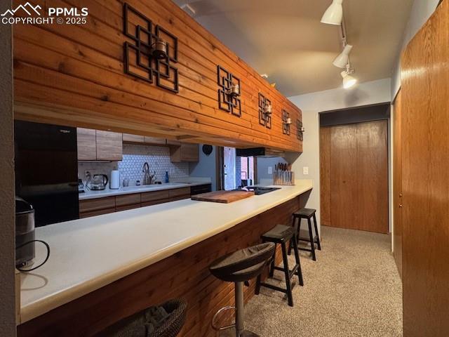 Kitchen featuring a kitchen bar w bar top seating 