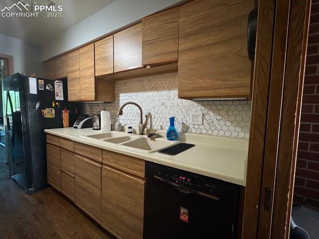 light countertops, backsplash, black appliances, dark wood-style flooring, and modern cabinetry