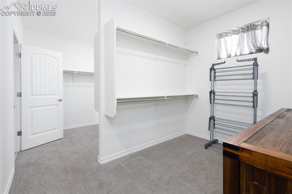 Primary Bedroom's walk-in closet with built-in shelves and access to the laundry room