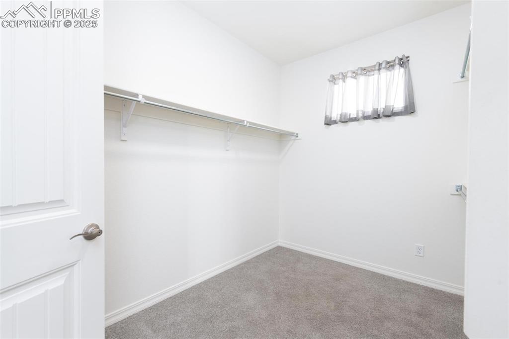Primary Bedroom's walk-in closet with built-in shelves and access to the laundry room