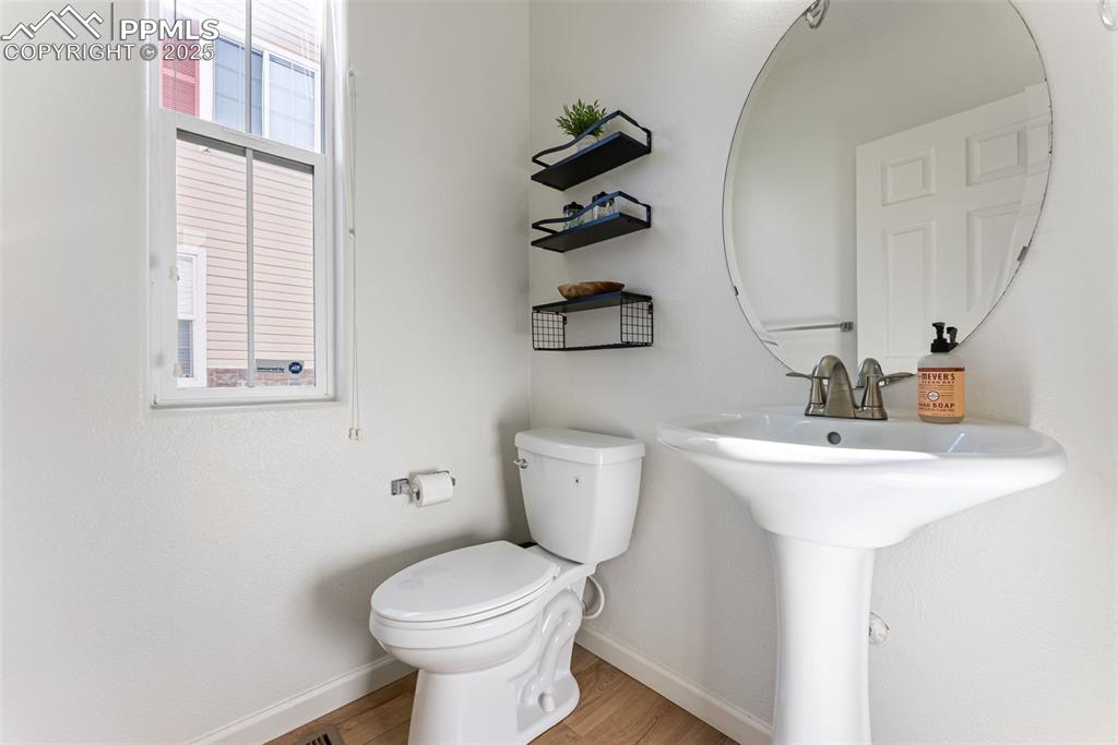 Half bathroom featuring light wood-type flooring and toilet