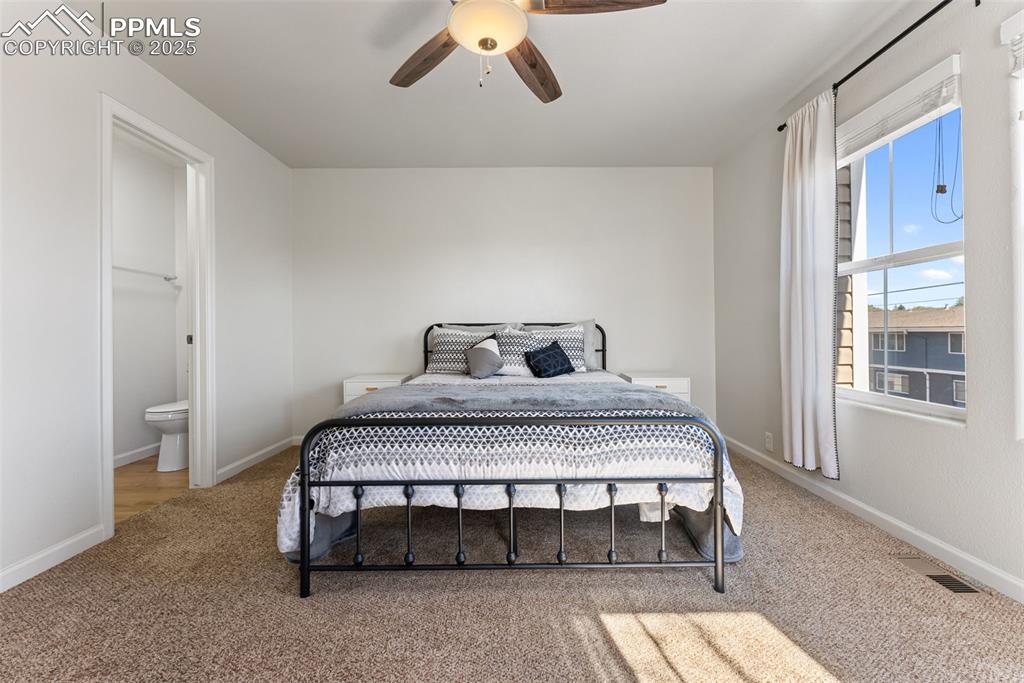 Bedroom with carpet flooring, ceiling fan, and ensuite bathroom