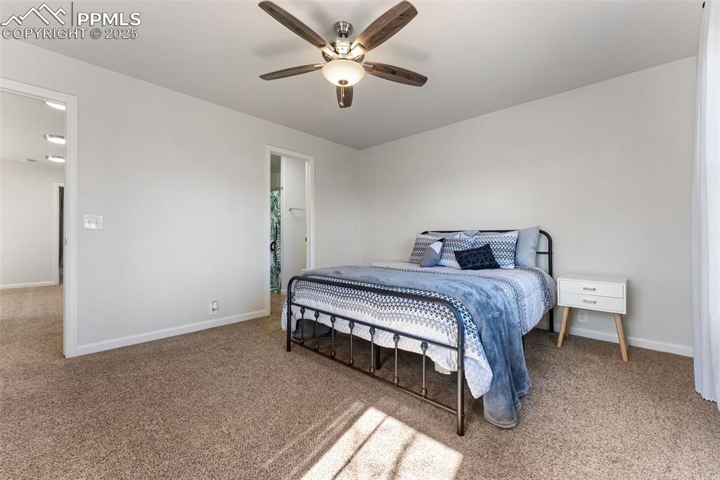 Bedroom with light carpet and a ceiling fan
