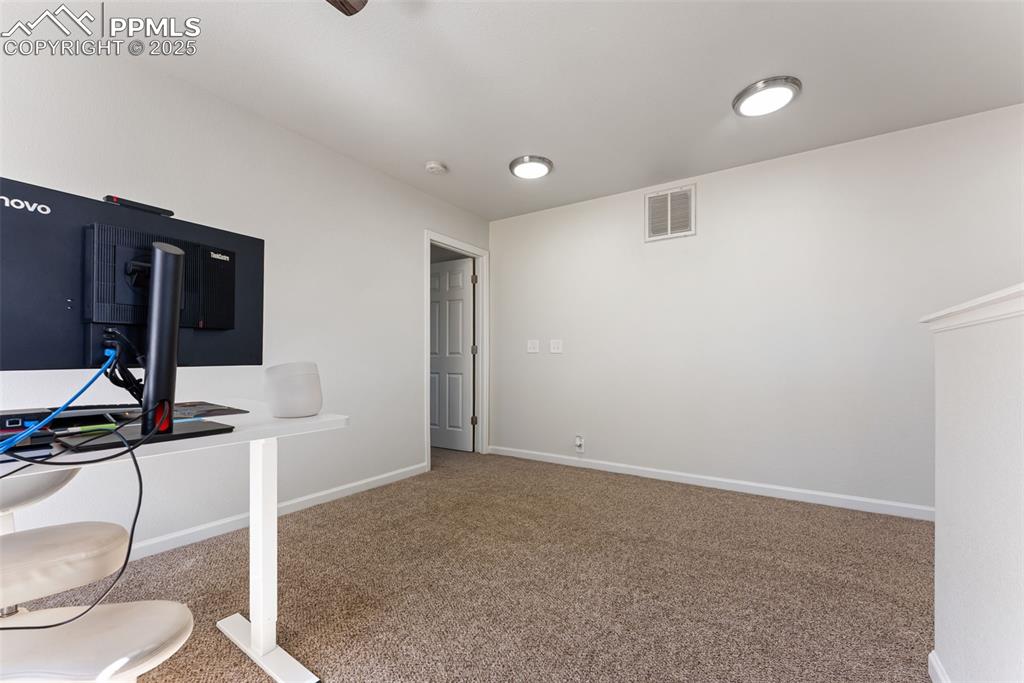 Unfurnished office featuring carpet and baseboards