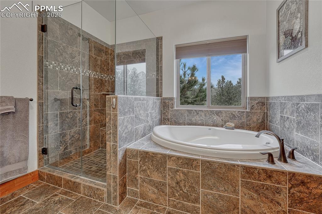 Bathroom featuring a garden tub and a shower stall
