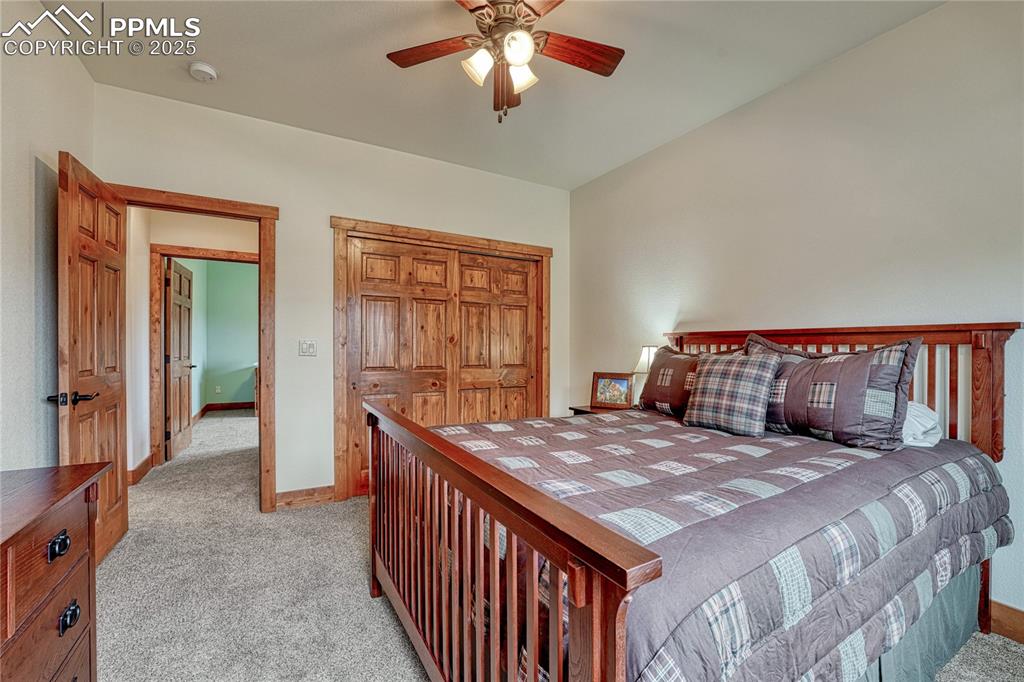 Bedroom featuring light carpet, baseboards, a closet, and a ceiling fan