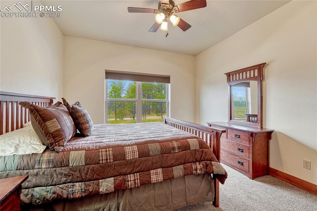 Carpeted bedroom with baseboards and ceiling fan