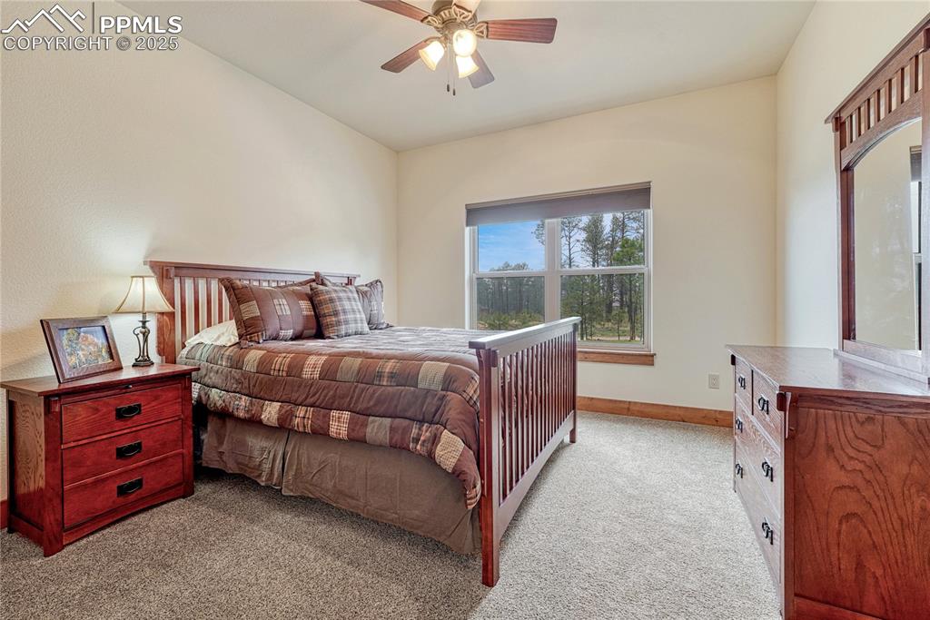 Carpeted bedroom with baseboards and a ceiling fan