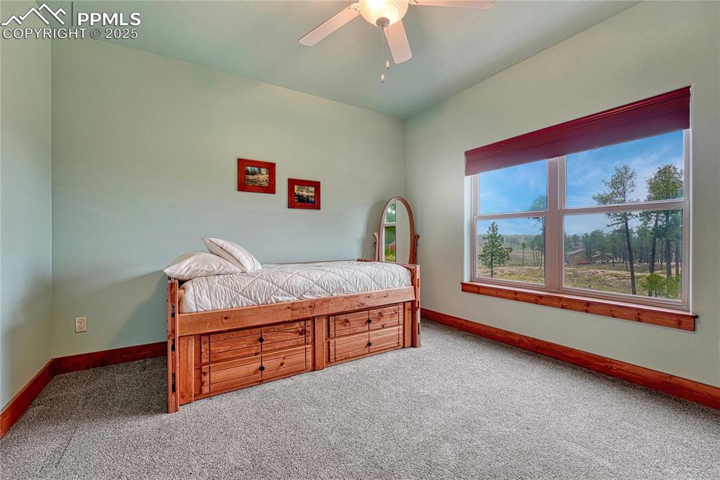 Carpeted bedroom featuring baseboards and ceiling fan